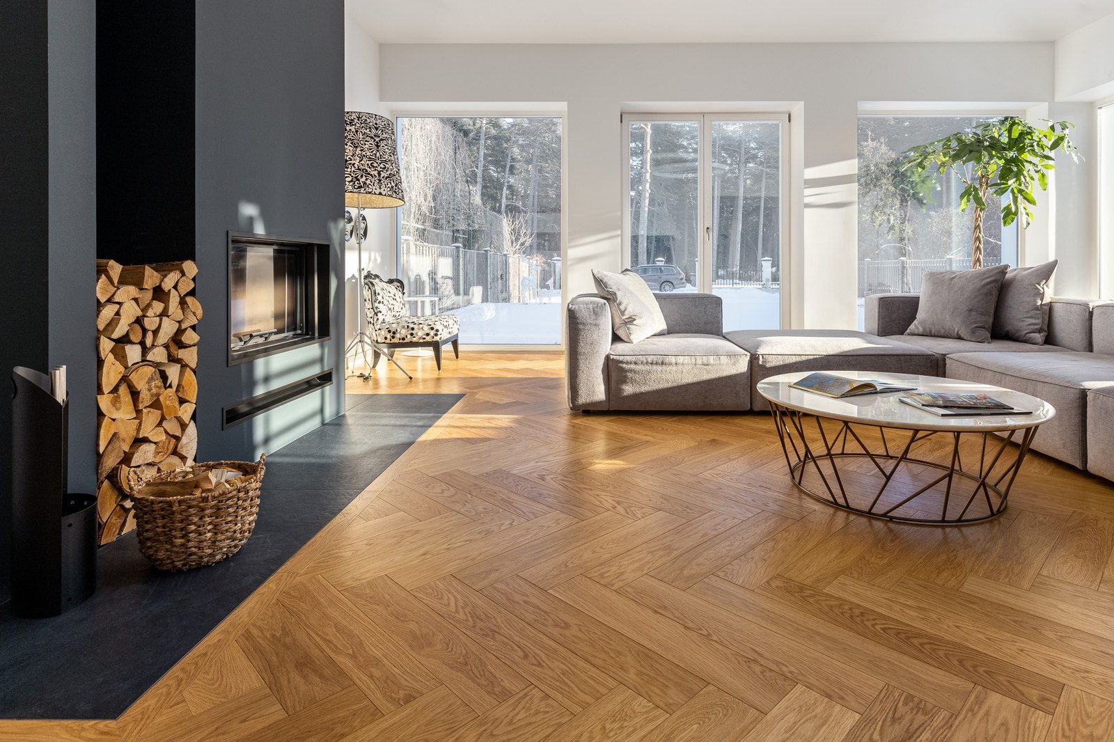 Herringbone-parkett i eik i stue med peis og store vinduer